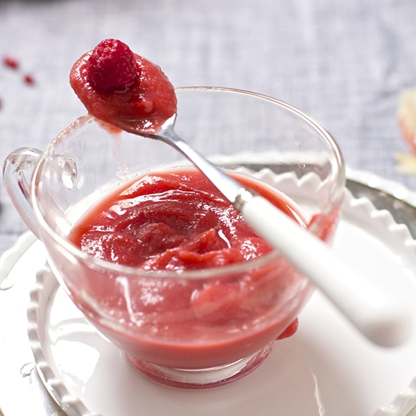 莓和苹果酱的图象在一个玻璃碗的有基于顶部的匙子的。
