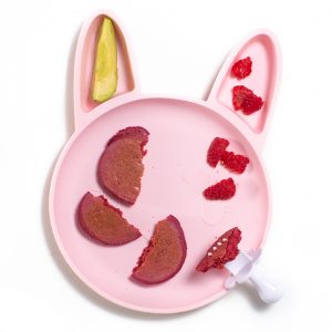 婴孩或小孩的桃红色兔宝宝盘用桃红色薄煎饼，莓和鲕梨。