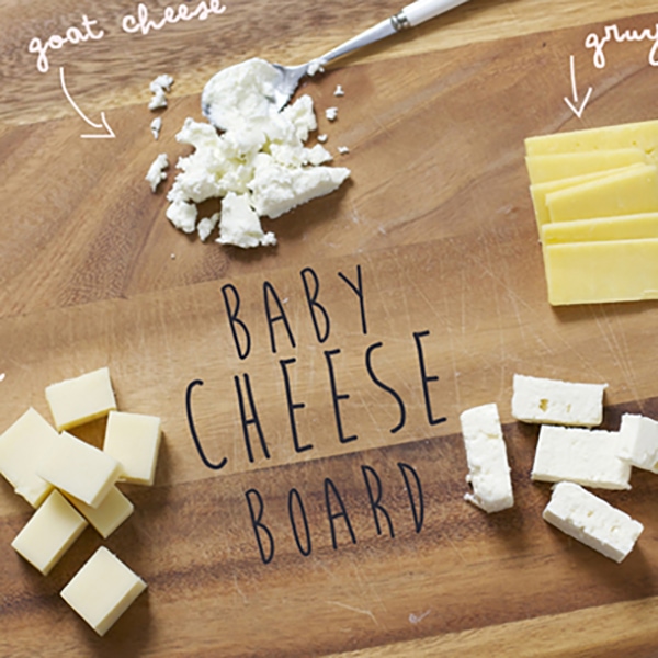 Cutting board with a selection of cheeses for baby on it.