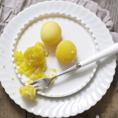 3煮熟的蛋黄在白色板上用叉子握住其中一个蛋黄的一部分。