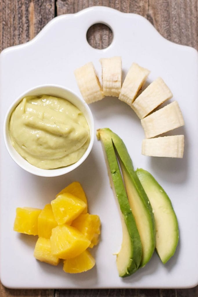 一个 小 的 砧板 ， 用 叉子 ， 把 香蕉 切成 小 块 ， 把 绿色 的 小 碗 和 一个 小 的 小 盘子 里 撒 上 。 