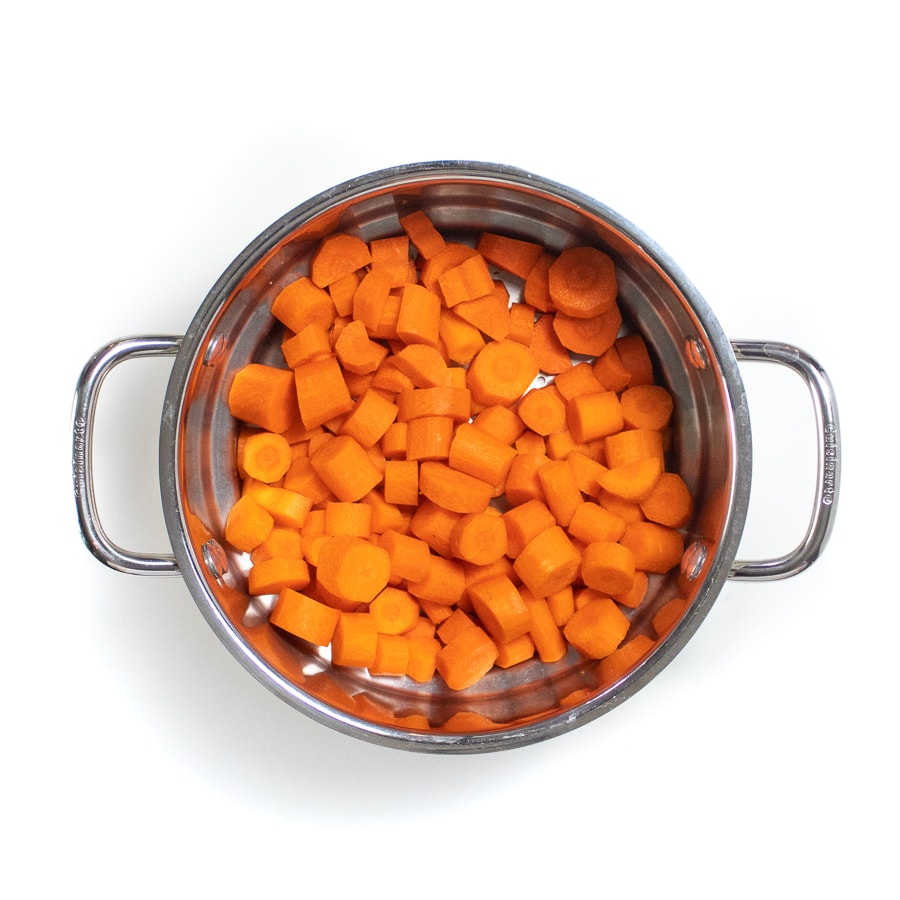 一个银色蒸锅篮，切成薄片的胡萝卜。