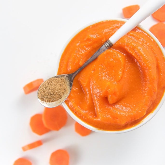 一个小碗，里面装满胡萝卜果，婴儿底部有胡萝卜。