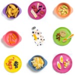 五颜六色的孩子盘子上有食物和婴儿的食物，上面供小吃。