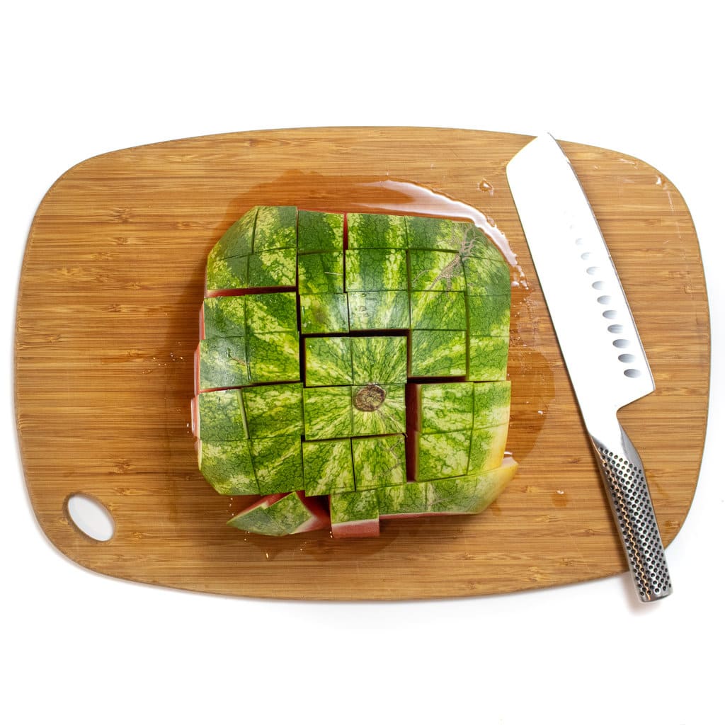 切菜板上的西瓜切成长条，上面有果皮。