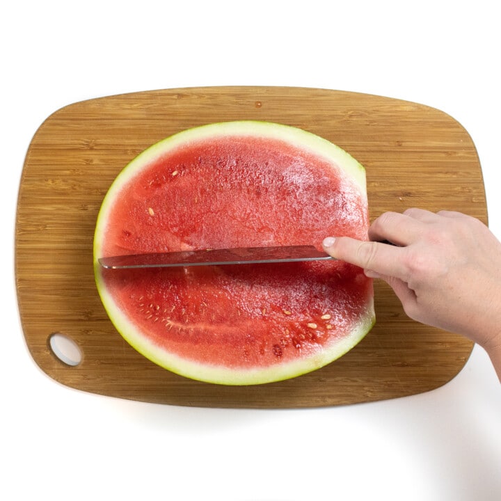 切菜板上的瓜是什么是握着刀将其切成两半的。