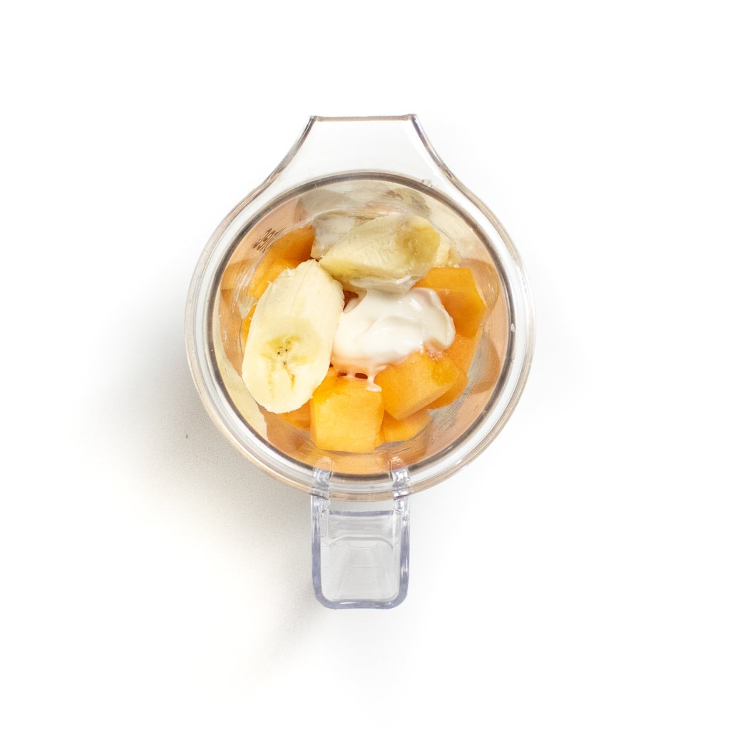 一个清晰的搅拌机，与哈密瓜，酸奶和香蕉。