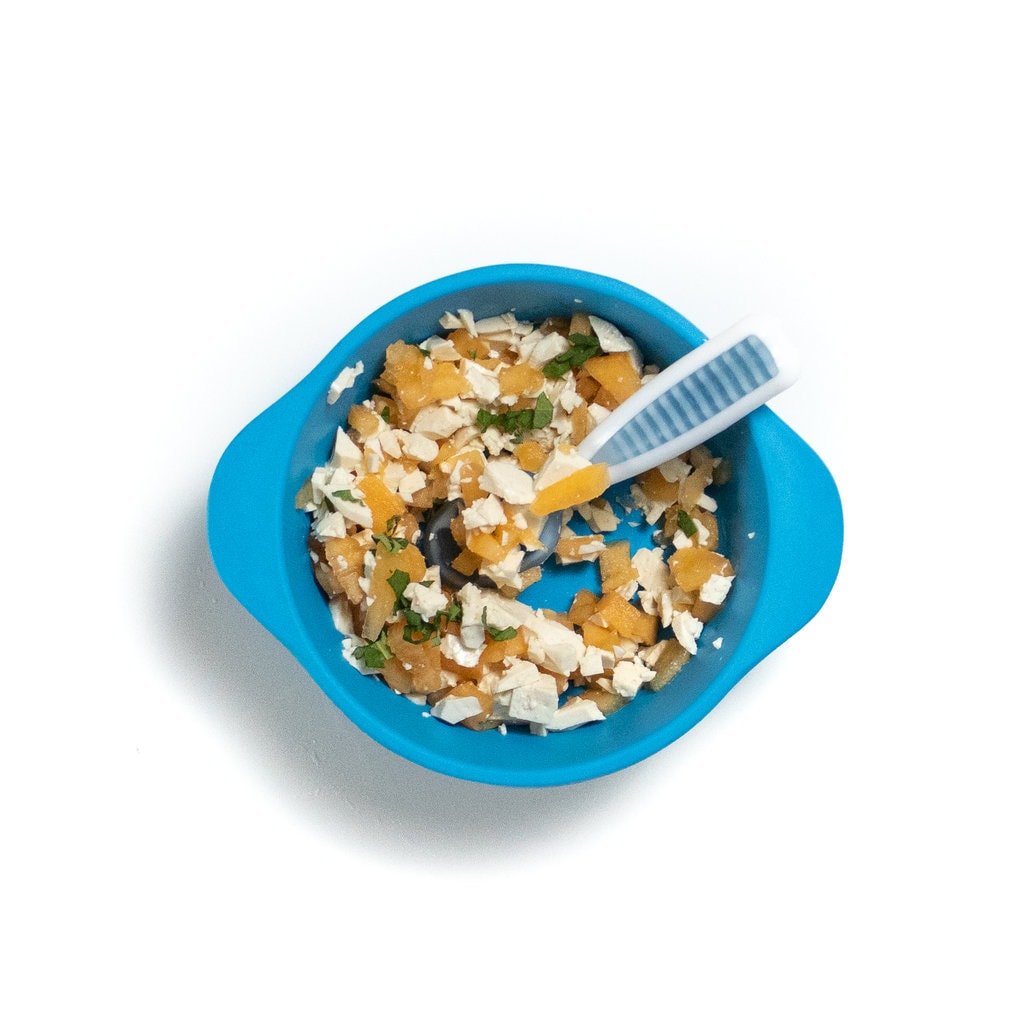 一个蓝色的婴儿碗，上面有一个矮胖的阶段，三块哈密瓜豆腐和薄荷。