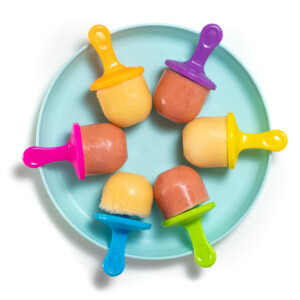 带有五颜六色的冰棒棒，哈密瓜和草莓哈密瓜冰棍的蓝绿色儿童板。