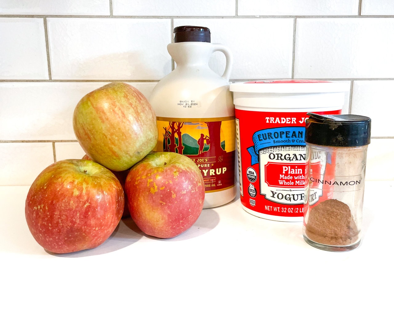 一个厨房柜台，配有苹果酸奶的成分 - 苹果，枫糖浆，酸奶，肉桂。