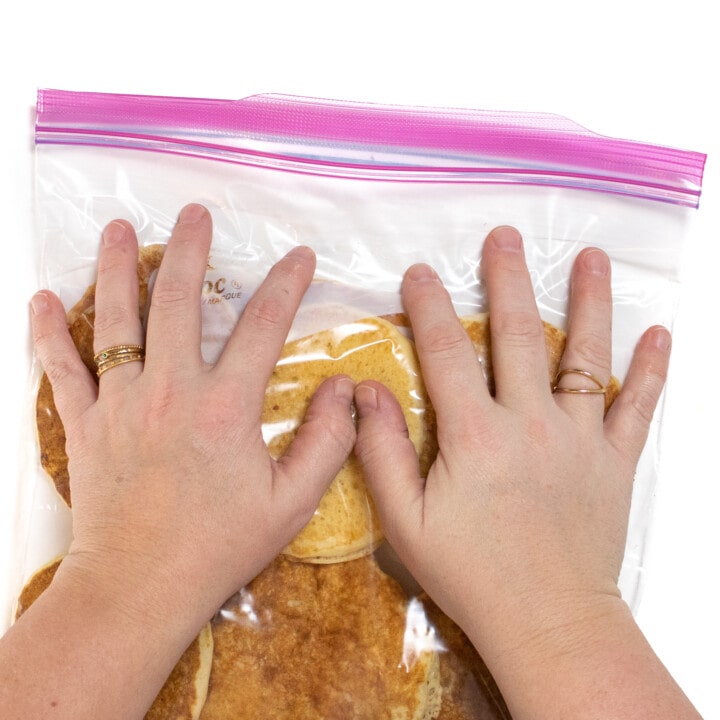两只手压在装满煎饼的Ziploc袋子上。
