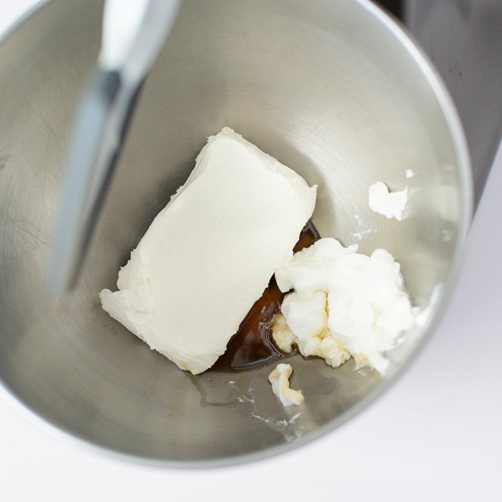 银色搅拌碗，里面装满了奶油奶酪，枫糖浆，香草和酸奶。
