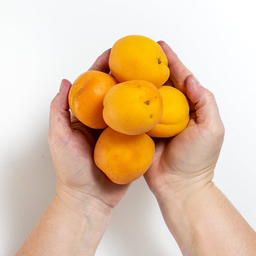 两只手握着一堆杏子。