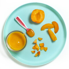 一个蓝色的孩子盘，有几种不同的方法将杏子喂给婴儿。