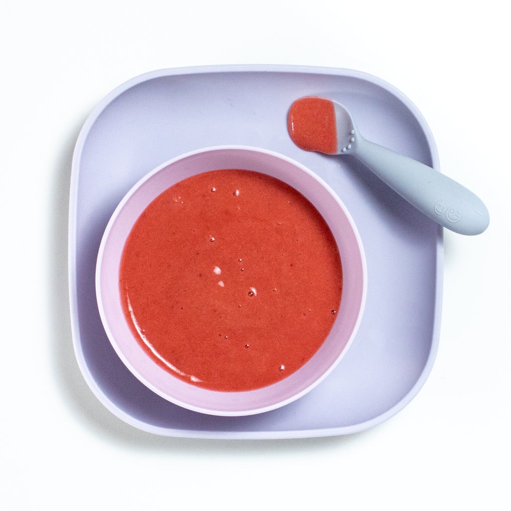 紫色小盘装满亮粉红色梅素 灰色小勺停在盘子上
