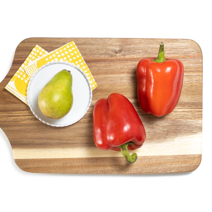 切菜板上的红辣椒和梨。