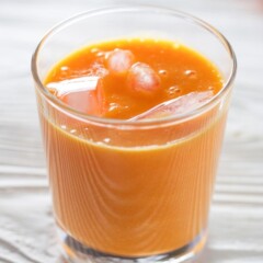 杯中胡萝卜和橙汁加冰