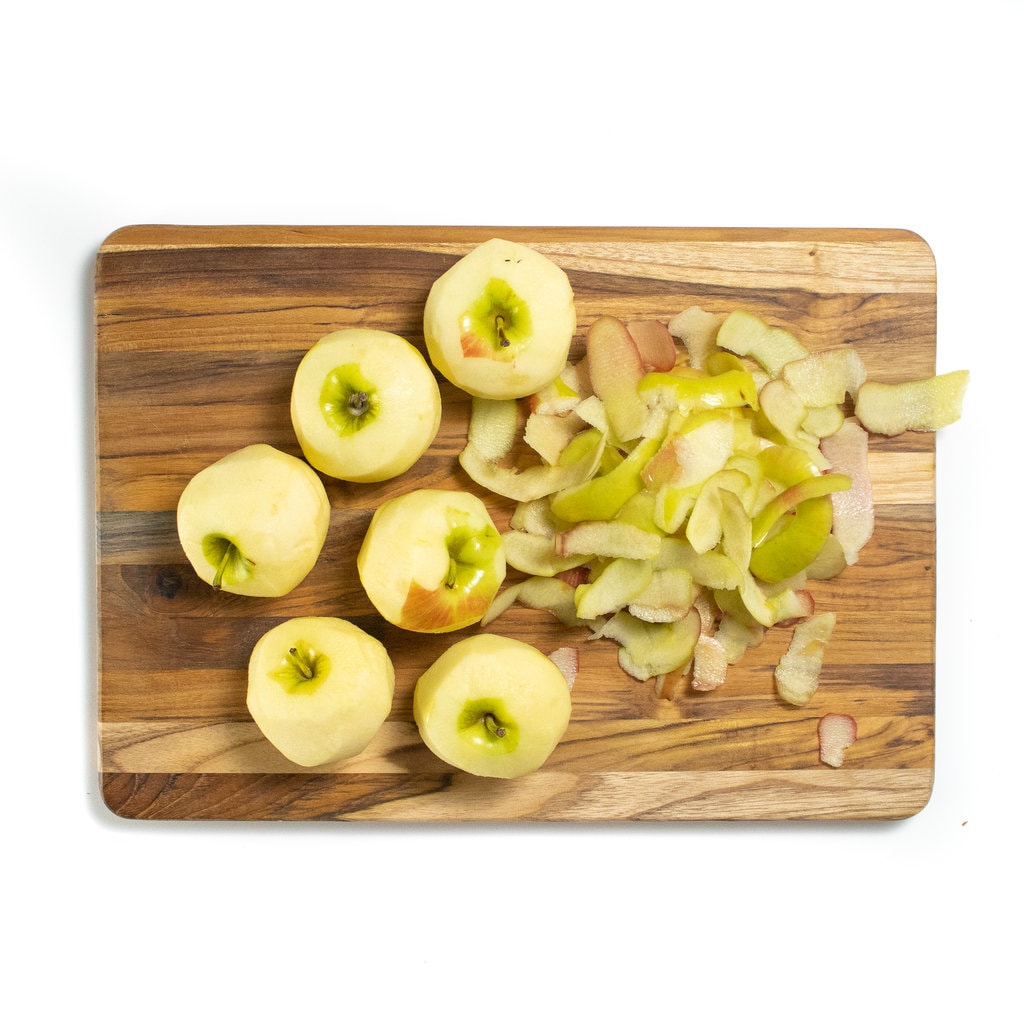 带剥皮苹果的木制切菜板。GydF4y2Ba