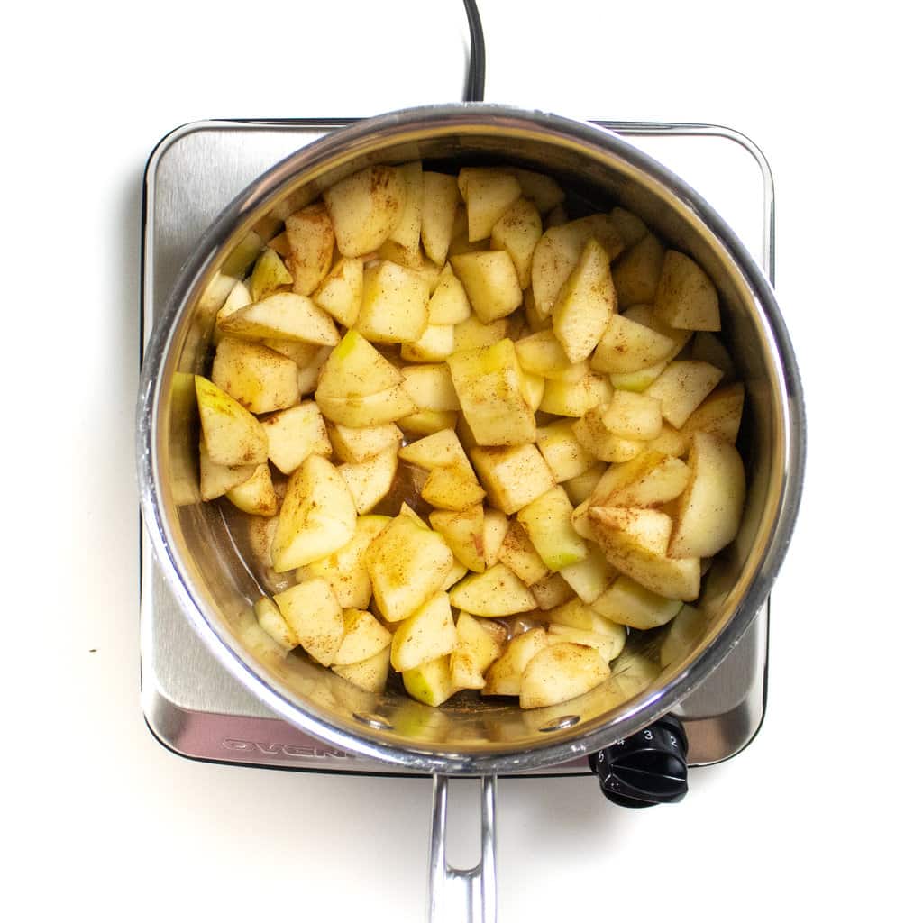 一个带有绿色苹果的银酱锅，肉桂和香草。GydF4y2Ba