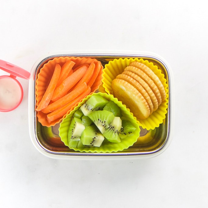 矩形小朋友盒和健康小吃-3松饼模子填满kiwi、胡萝卜棒和crackers侧面有小粉红色容器填充牧场布局