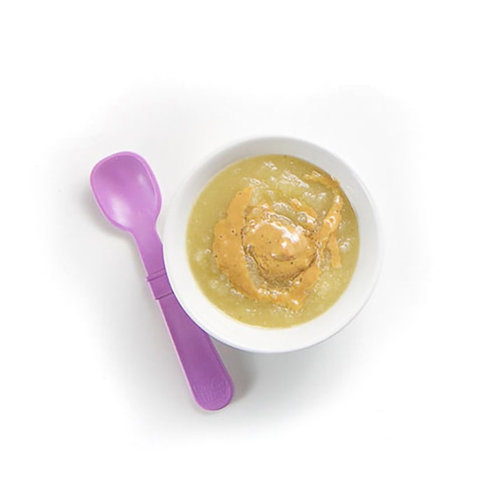 小婴儿碗，配紫色汤匙，苹果果泥和细雨杏仁黄油。