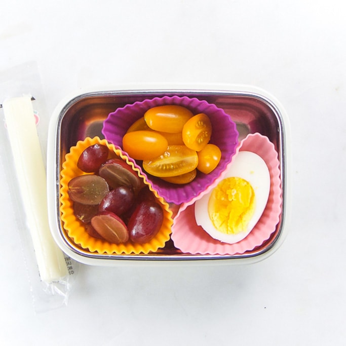 矩形小朋友盒和健康小吃-3松饼模子填满切葡萄、切樱桃番茄和半硬煮鸡蛋侧边是字符串起司