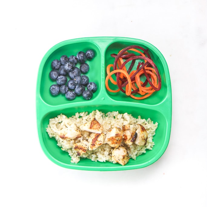白面上三片板装满健康小菜-鸡饭、米饭、蓝莓菜菜和萝卜