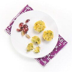 白板悬在白面紫餐巾上盘子上有3小菜花椰菜奎诺亚咬和一小片切葡萄奎诺亚咬半叉子吃