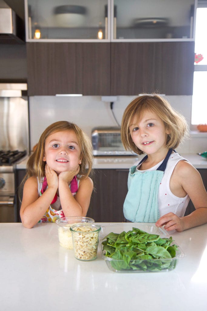 2个女孩站在厨房柜台前传播食谱素材