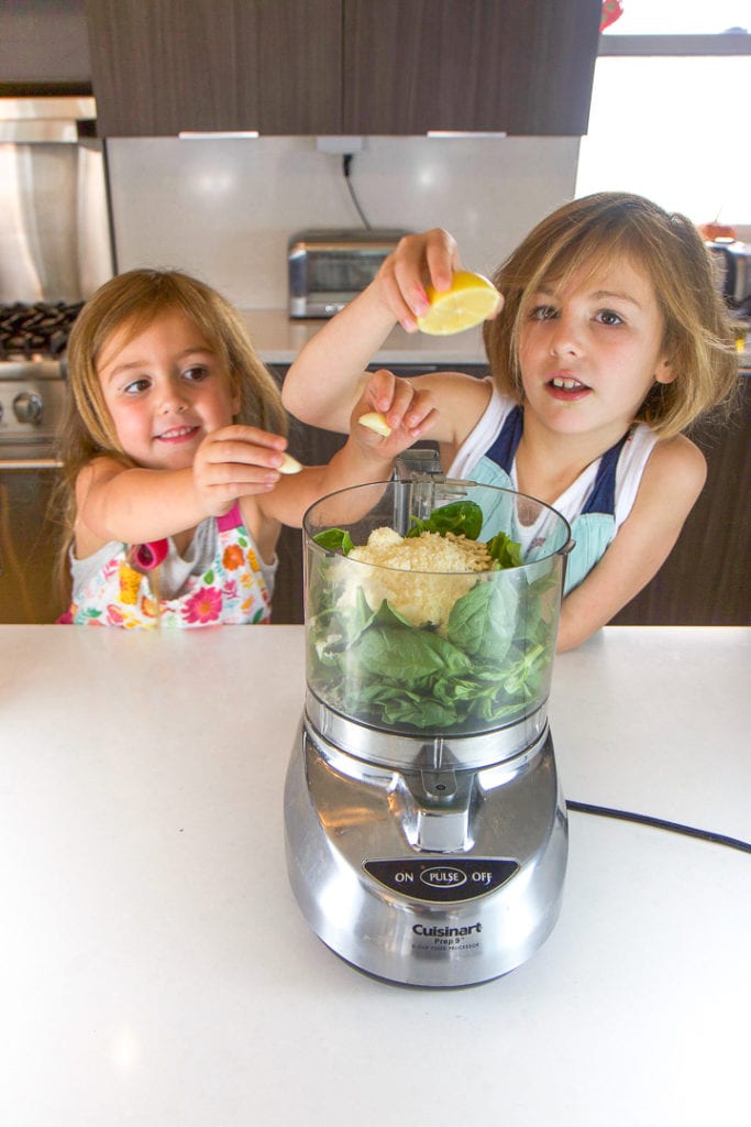 2个女孩把项目放进食品处理器-与孩子一起做饭