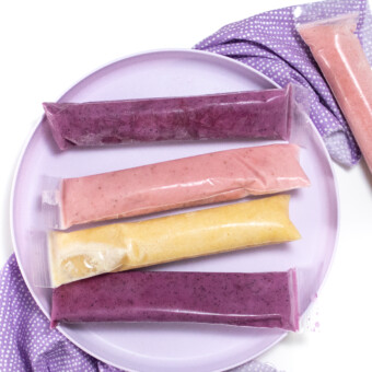紫色小朋友玩三种不同颜色的酸奶管