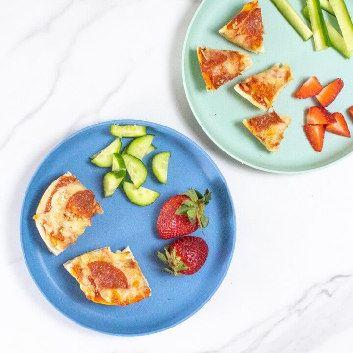 双蓝孩子盘装百果比萨 切成不同尺寸 黄瓜和草莓加大理石柜