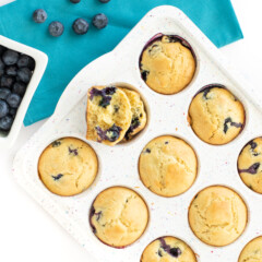 带点白松饼盘加熟蓝莓松饼背面蓝桌布并分布蓝莓