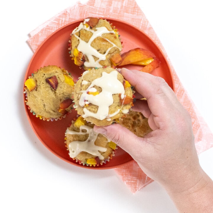 手握桃松饼和奶油芝士滑盘 粉红小朋友盘顶上几片桃松饼