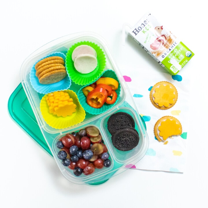 散开儿童午餐盒自制火鸡和芝士午餐盒 餐巾纸 果汁和午餐盒 半吃白柜台