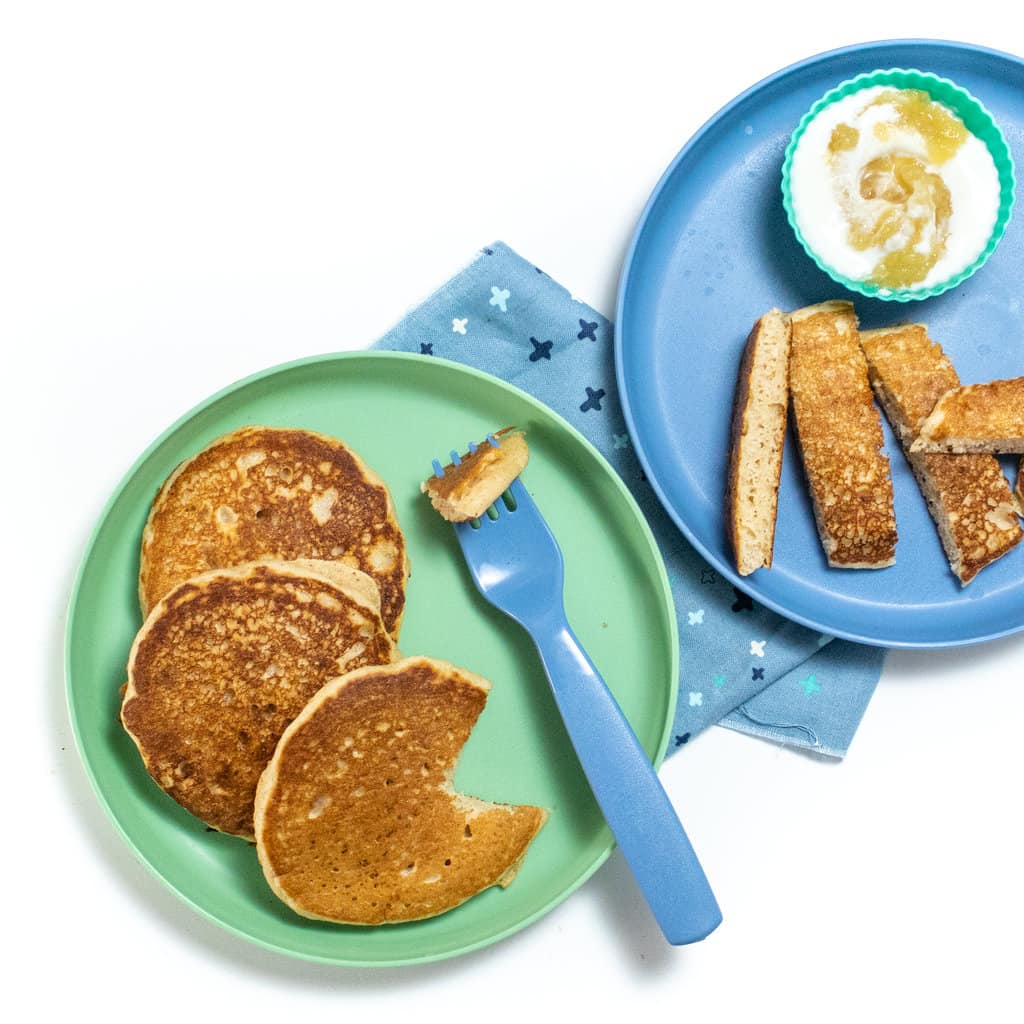 2个蓝孩子盘子和苹果酱饼 切成不同形状 小碗酸奶和苹果酱 叉蓝餐巾