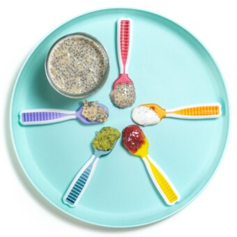 Teal小盘白后台5种彩虹色勺子展示向婴儿提供千兆种子的不同方式