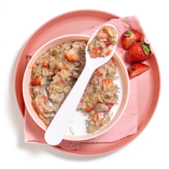 平面小朋友 碗盘和粉红色餐巾 碗里满满草莓燕麦片